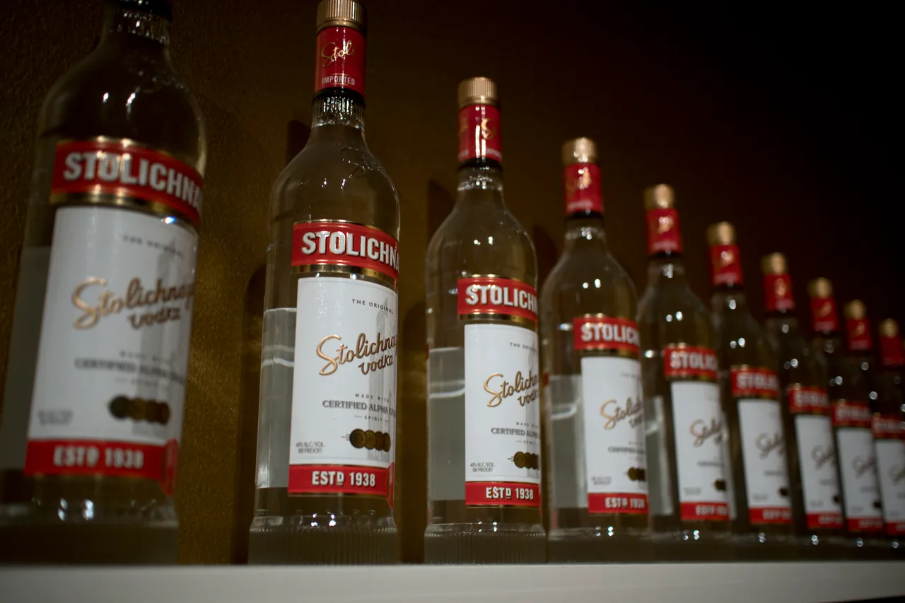 Fileira de garrafas de Stolichnaya vodka expostas lado a lado em uma prateleira